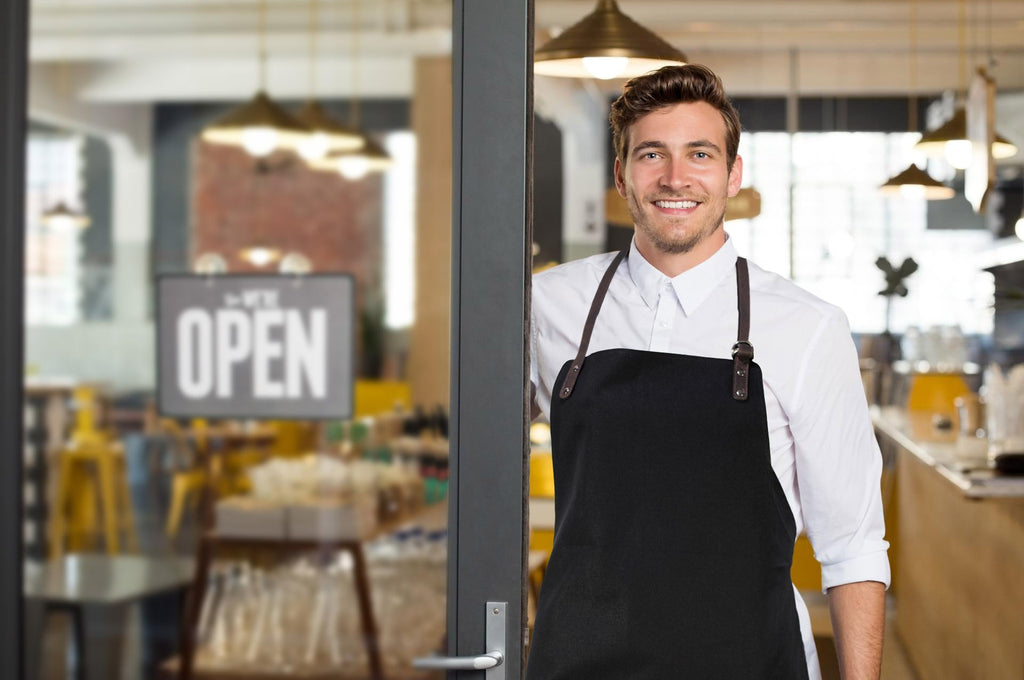 K0015AB | Canvas/ Genuine full-grain leather, ruffled Work Apron. Black/Brown head color. Nickel Antique Accessories. Dimensions: 70 x 90 x 0.5 cm. Packaging: Polybag